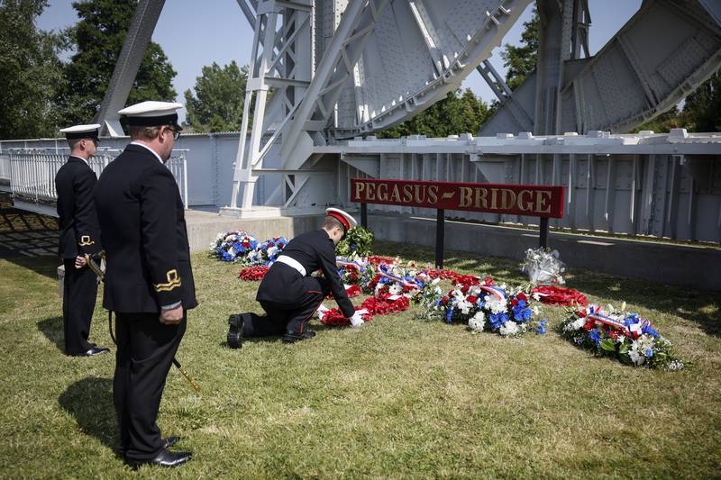 Military officials lay a wreath of flowers at the Pegasus Bridge, one of the first sites liberated by Allied forces from Nazi Germany, in Benouville, Normandy, Monday, June 5, 2023.