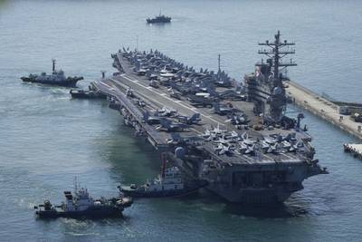 The aircraft carrier USS Ronald Reagan is escorted as it arrives in Busan, South Korea on Sept. 23, 2022.