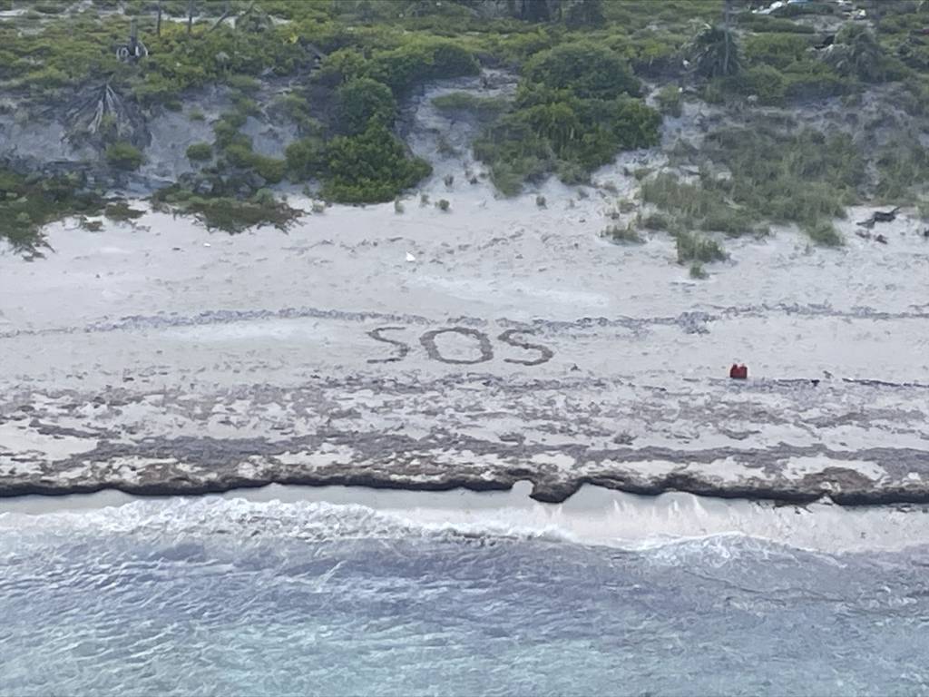 This photo provided by the U.S. Coast Guard shows the letters SOS etched in the sand during the Coast Guard's rescue on Friday, Aug. 18, 2023, of a 64-year-old man who spent three days stranded on an island in the Bahamas until being rescued.