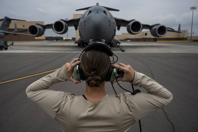 Senior Airman Sara Gutherie, 911th Aircraft Maintenance Squadron instruments and controls technician, adjusts her headset to communicate with maintainers inside the C-17 Globemaster III during an inspection at the Pittsburgh International Airport Air Reserve Station, Pa., Sept. 17, 2020.