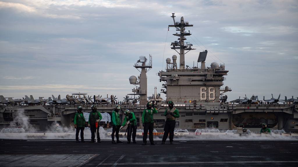 U.S. sailors observe flight operations from the flight deck of the aircraft carrier USS Theodore Roosevelt (CVN 71) while conducting dual-carrier operations with the Nimitz Carrier Strike Group in the South China Sea Feb. 9, 2021