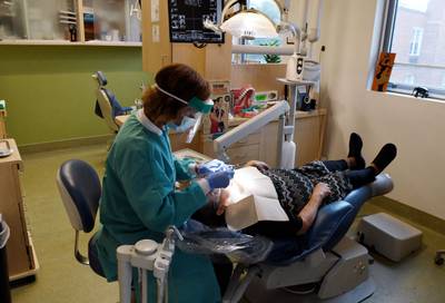 A registered dental hygienist works on a patient at a dental clinic on Oct. 28, 2021, in Washington, D.C.