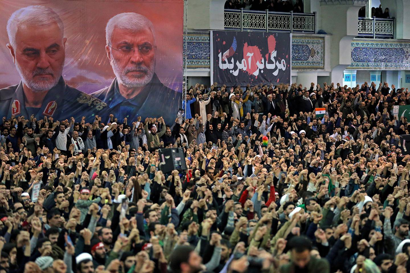 In this Jan. 17, 2020, file photo, released by the official website of the office of the Iranian supreme leader, worshippers chant slogans during Friday prayers ceremony, as a banner show Iranian Revolutionary Guard Gen. Qassem Soleimani, left, and Iraqi Shiite senior militia commander Abu Mahdi al-Muhandis, who were killed in Iraq in a U.S. drone attack on Jan. 3, and a banner which reads in Persian: "Death To America, "at Imam Khomeini Grand Mosque in Tehran, Iran.