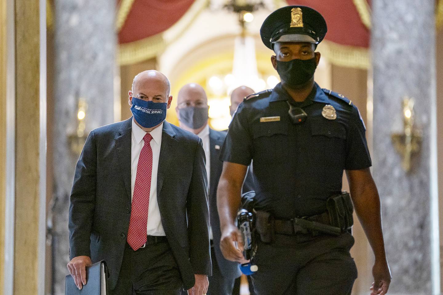 Postmaster General Louis DeJoy, left, is escorted to House Speaker Nancy Pelosi's office on Capitol Hill in Washington, Wednesday, Aug. 5, 2020.