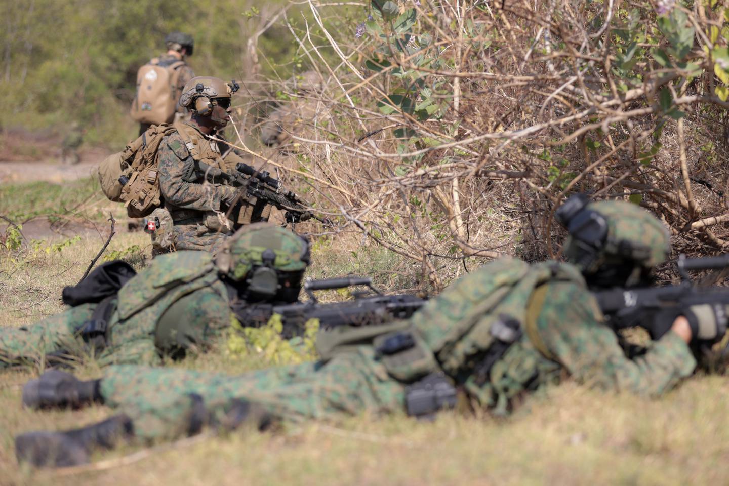 A U.S. Marine and and Singaporean soldiers take their positions during an amphibious landing operation at the Super Garuda Shield multi-national military exercise in Situbondo, East Java, Indonesia, Sunday, Sept. 10, 2023.