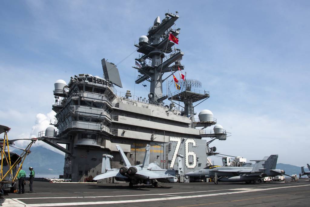 In this photo provided by U.S. Navy, the United States and Vietnam national ensigns are raised in unison on the aircraft carrier Ronald Reagan in Da Nang, Vietnam, for a port visit, Sunday, June 25, 2023.