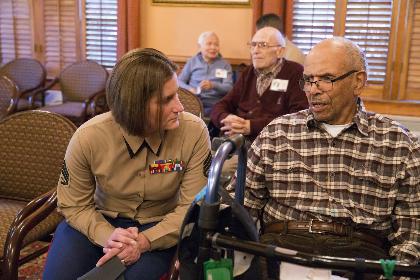 Marine Corps Staff Sgt. Amanda J. Eason, a planner at Marine Corps Base Quantico, speaks with a resident at the Heatherwood Retirement Home during a Veterans Day visit in Burke, Virginia, in 2016.