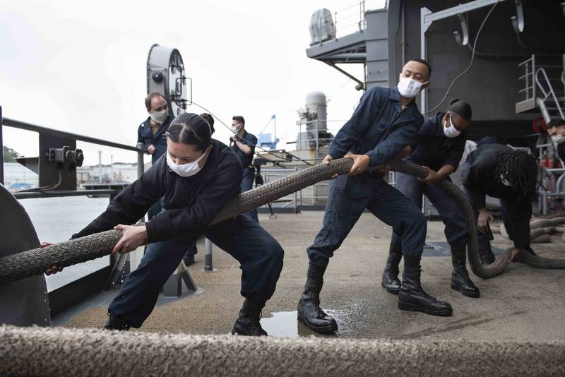 Sailors heave a mooring line on the fantail of the Navy's only forward-deployed aircraft carrier, the USS Ronald Reagan (CVN 76), in preparation to get the ship underway on May 21, 2020, in Yokosuka, Japan.