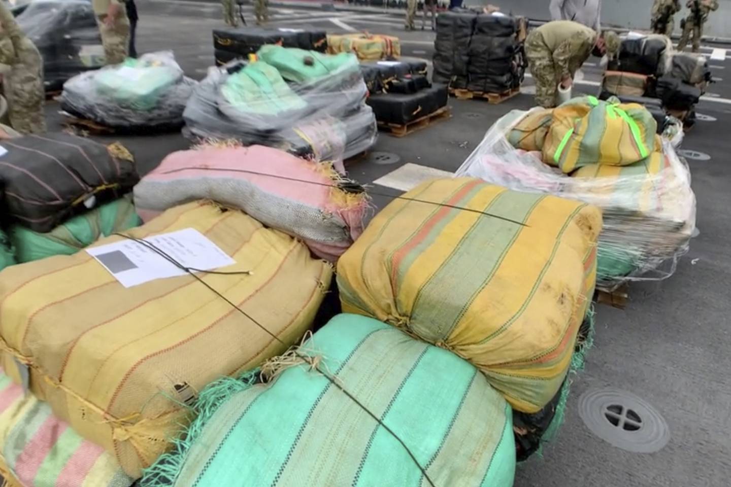 In this photo taken from video, provided by the U.S. Coast Guard and U.S. Navy, personnel offload approximately 11,400 pounds of cocaine and 9,000 pounds of marijuana, with an estimated worth of $211 million, from the USS Gabrielle Giffords in San Diego on Feb. 1, 2021.