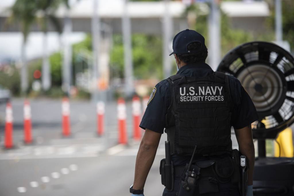 Guard Officer Luis Abreu, a Navy police officer, stands post at the Makalapa gate at Joint Base Pearl Harbor-Hickam, Hawaii, April 13, 2020. (Specialist 2nd Class Charles Oki/U.S. Navy)