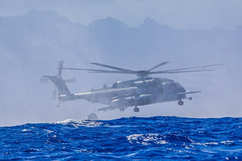 Marines approach the water with a CH-53E Super Stallion helicopter during helicopter casting training with U.S. Navy sailors off the island of Oahu, Hawaii, June 30, 2020.