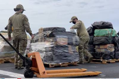 In this photo taken from video, provided by the U.S. Coast Guard and U.S. Navy, personnel offload approximately 11,400 pounds of cocaine and 9,000 pounds of marijuana, with an estimated worth of $211 million, from the USS Gabrielle Giffords in San Diego on Feb. 1, 2021.