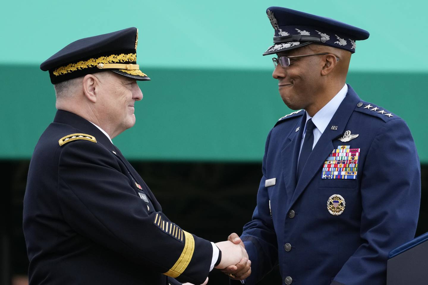 Retiring Chairman of the Joint Chiefs of Staff Gen. Mark Milley, left, shakes hands with Gen. CQ Brown, Jr., the incoming chairman, right, during the Armed Forces Farewell Tribute in honor of Milley at Joint Base Myer-Henderson Hall, Friday, Sept. 29, 2023, in Fort Meyer, Va.