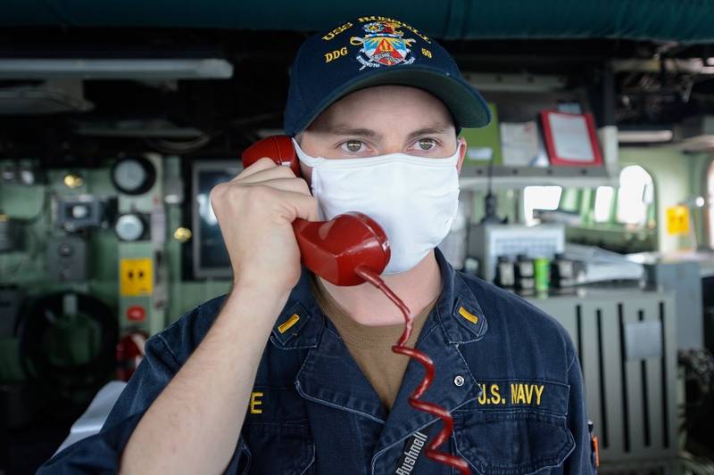 Ensign Tyler Love communicates with the combat information center watch team from the pilot house June 4, 2020, as the Arleigh Burke-class guided-missile destroyer USS Russell (DDG 59) transits the Taiwan Strait.