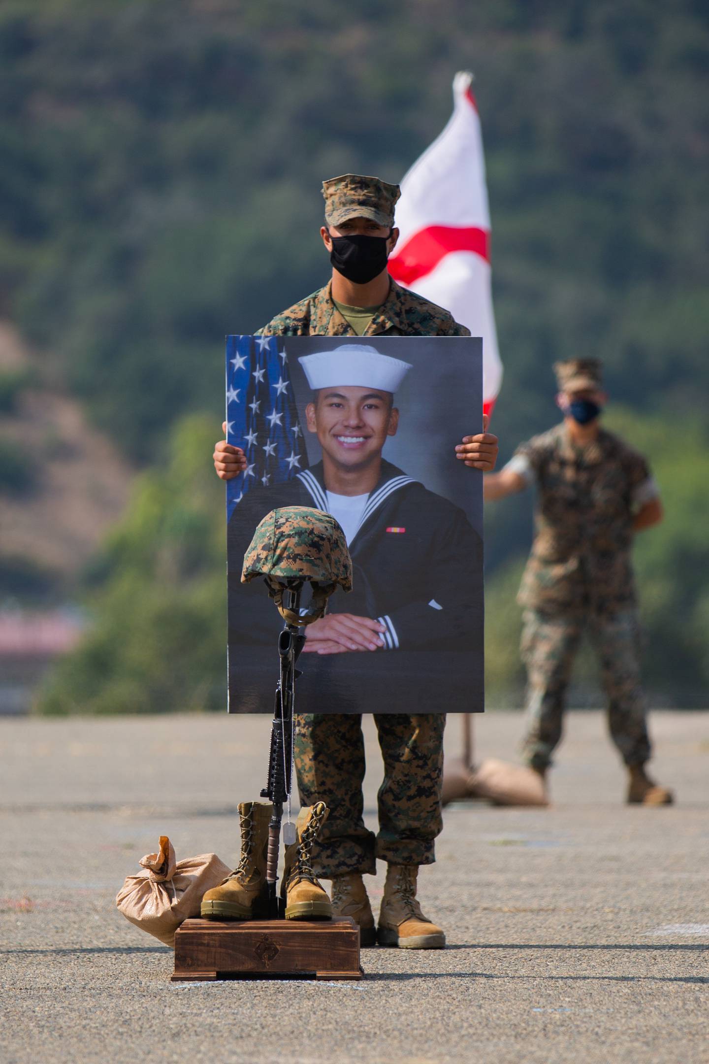 A Marine holds the portrait of Navy Hospital Corpsman 3rd Class (Fleet Marine Force) Christopher Gnem during a memorial service at Marine Corps Base Camp Pendleton, California, Aug. 21, 2020.