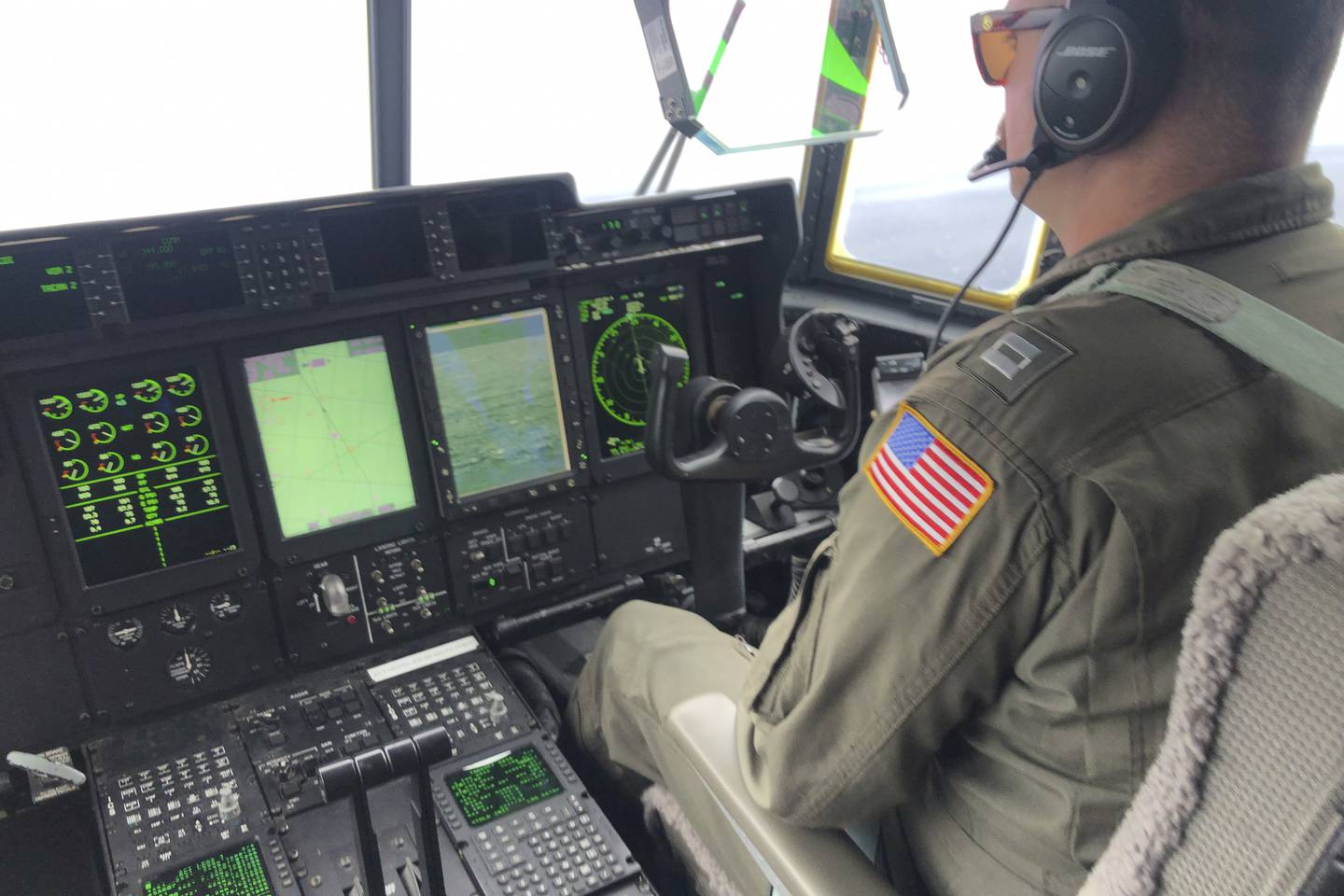 In this image provided by the U.S. Coast Guard, a crew member sits aboard a Coast Guard HC-130 Hercules airplane based at Coast Guard Air Station Elizabeth City, N.C., as it flies about 900 miles East of Cape Cod, Mass., during the search for the 21-foot submersible, Titan, Wednesday, June 21, 2023.