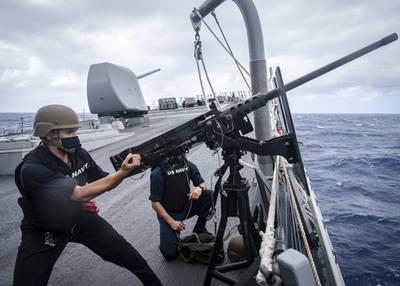 Fire Controlman 2nd Class Samuel Thomas "racks" an M2HB .50-caliber machine gun on the foc’s’le during a small craft attack team drill aboard the Arleigh Burke-class guided-missile destroyer USS John S. McCain (DDG 56) on Oct. 7, 2020, in the South China Sea.