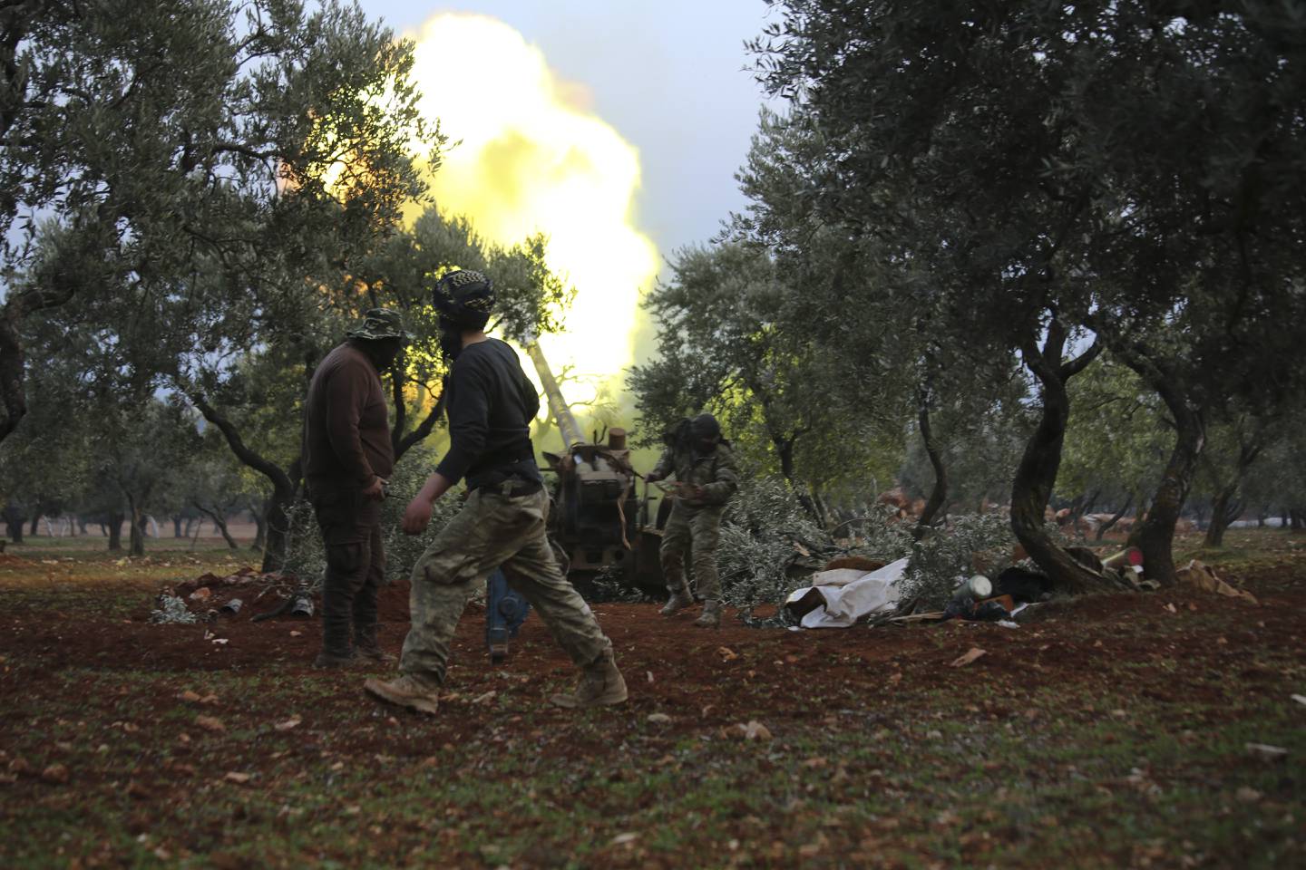 Syrian rebel fighters fire a howitzer