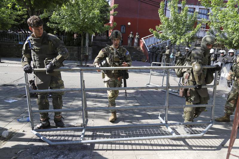 KFOR soldiers set up a security fence in front of a municipal building after yesterday's clashes between ethnic Serbs and troops from the NATO-led KFOR peacekeeping force, in the town of Zvecan, northern Kosovo, Tuesday, May 30, 2023.