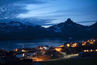 Homes are illuminated after the sunset in Tasiilaq, Greenland, late Friday, Aug. 16, 2019.