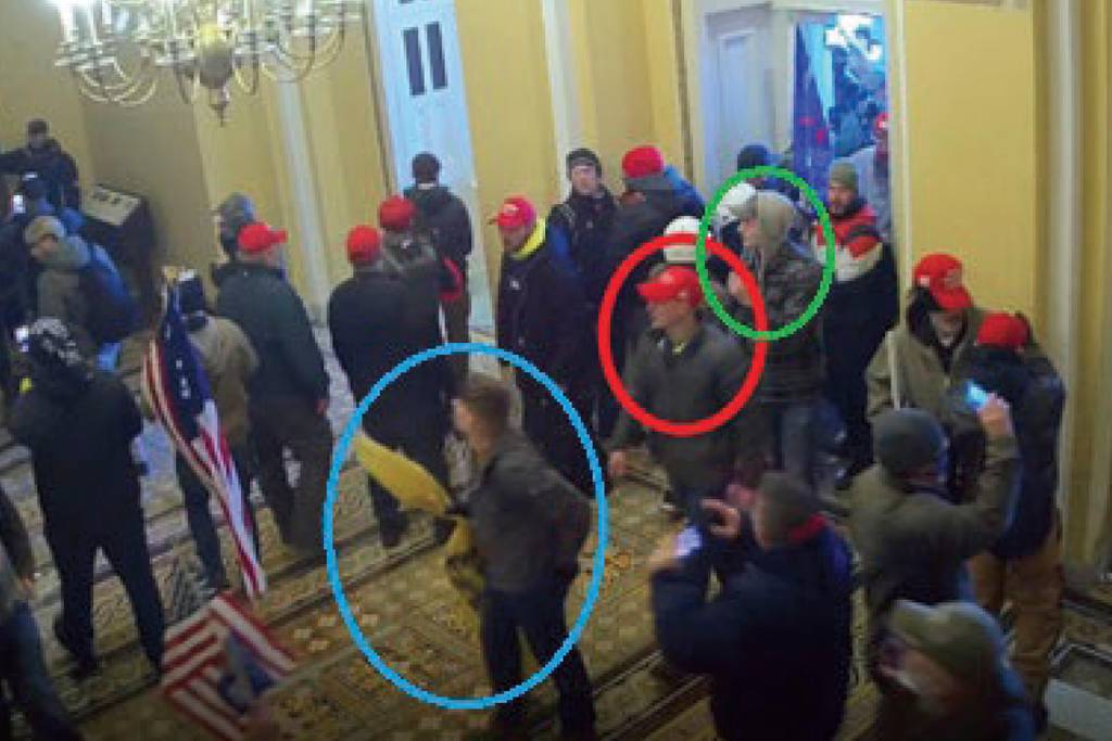 In this image from U.S. Capitol Police video, released and annotated by the Justice Department in the Statement of Facts supporting an arrest warrant, Joshua Abate, circled in green, Micah Coomer, circled in red, and Dodge Dale Hellonen, circled in blue, appear inside the U.S. Capitol on Jan. 6, 2021, in Washington.