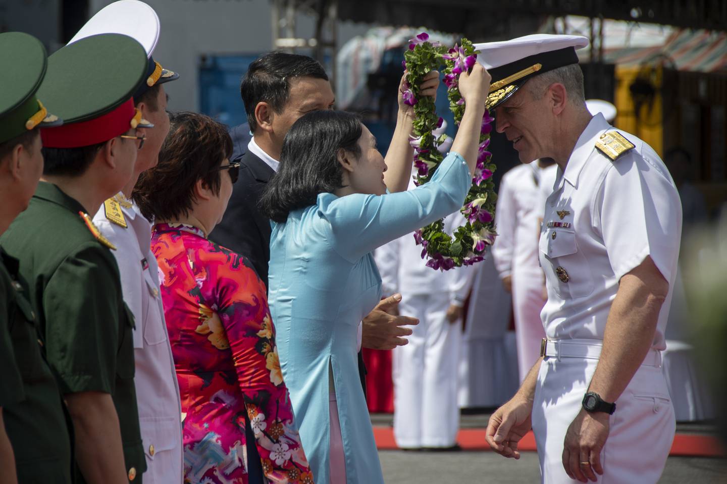 In this photo provided by U.S. Navy, Rear Adm. Pat Hannifin, right, receives a wreath during a welcome ceremony after the aircraft carrier Ronald Reagan, anchored into Da Nang, Vietnam, for a routine port visit, Sunday, June 25, 2023.
