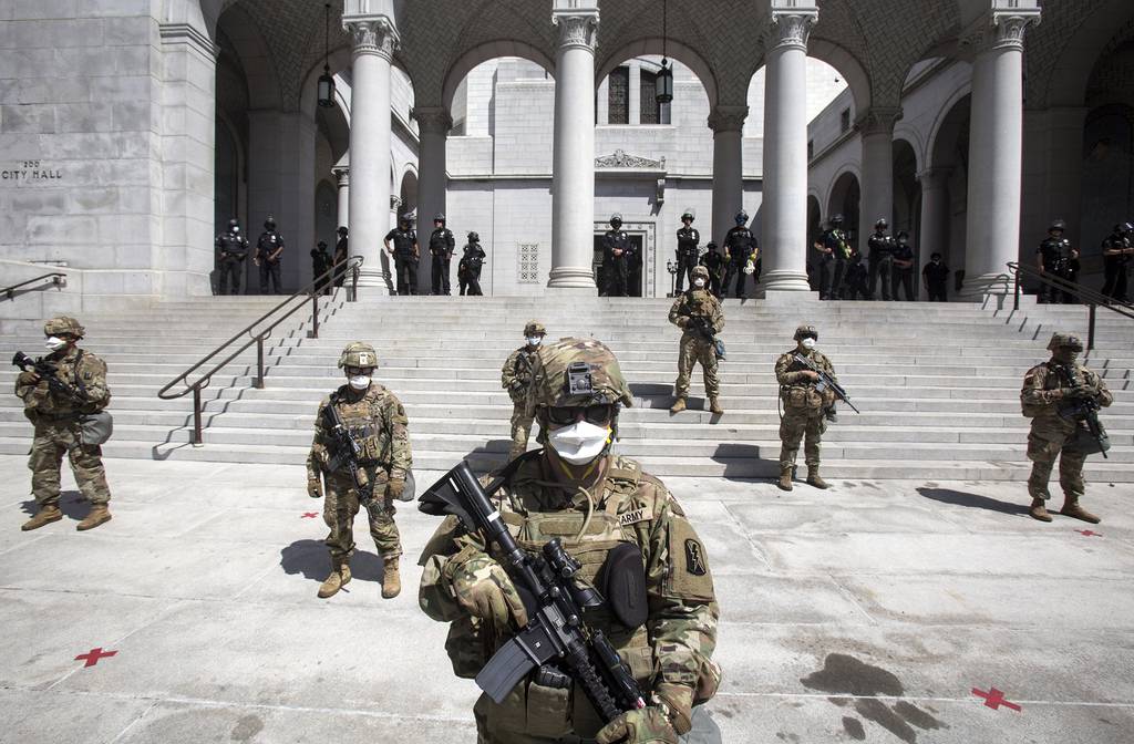 Members of California National Guard stand guard outside the City Hall, Sunday, May 31, 2020, in Los Angeles.