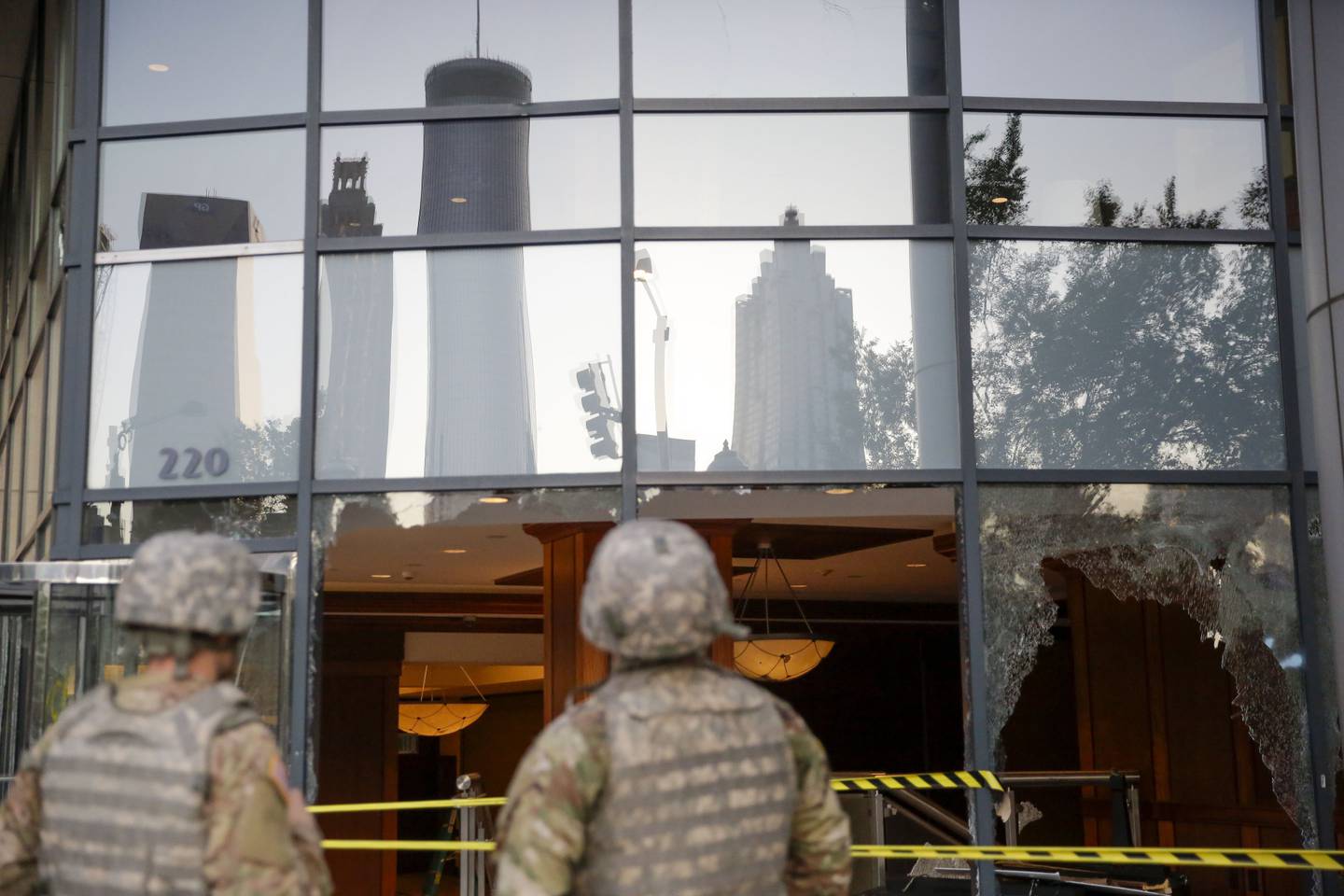 The National Guard looks at the damage done to downtown Atlanta in the aftermath of a demonstration against police violence on Saturday, May 30, 2020, in Atlanta.