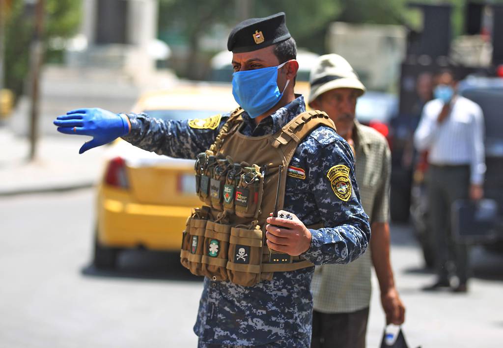 Members of the Iraqi security forces wearing protective masks keep watch at Tahrir Square in central Baghdad on May 14, 2020, during the Muslim holy month of Ramadan after authorities eased up the lockdown measures that they had imposed in a bid to slow the spread of the novel coronavirus.