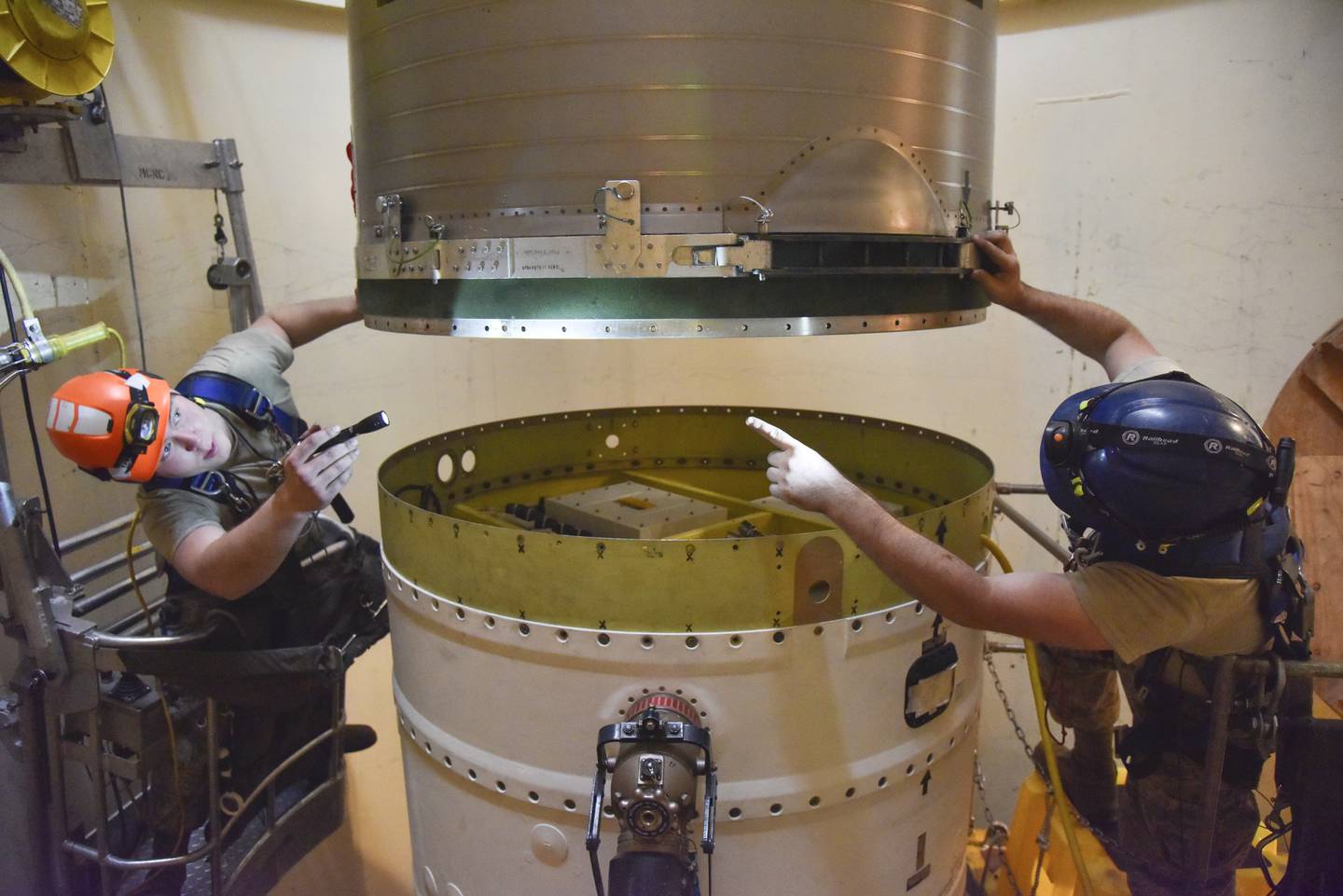In this image provided by the U.S. Air Force, Airman 1st Class Jackson Ligon, left, and Senior Airman Jonathan Marinaccio, 341st Missile Maintenance Squadron technicians connect a re-entry system to a spacer on an intercontinental ballistic missile during a Simulated Electronic Launch-Minuteman test Sept. 22, 2020, at a launch facility near Malmstrom Air Force Base in Great Falls, Mont.
