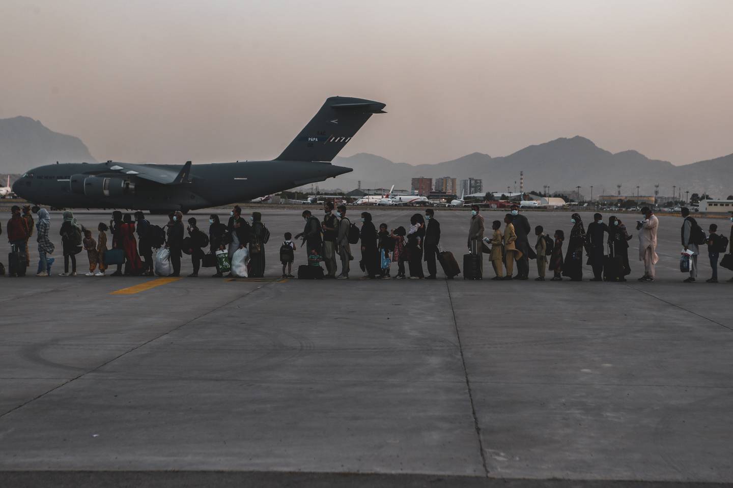 Evacuees wait to board a Boeing C-17 Globemaster III during an evacuation at Hamid Karzai International Airport, Kabul, Afghanistan, Aug. 23, 2021.