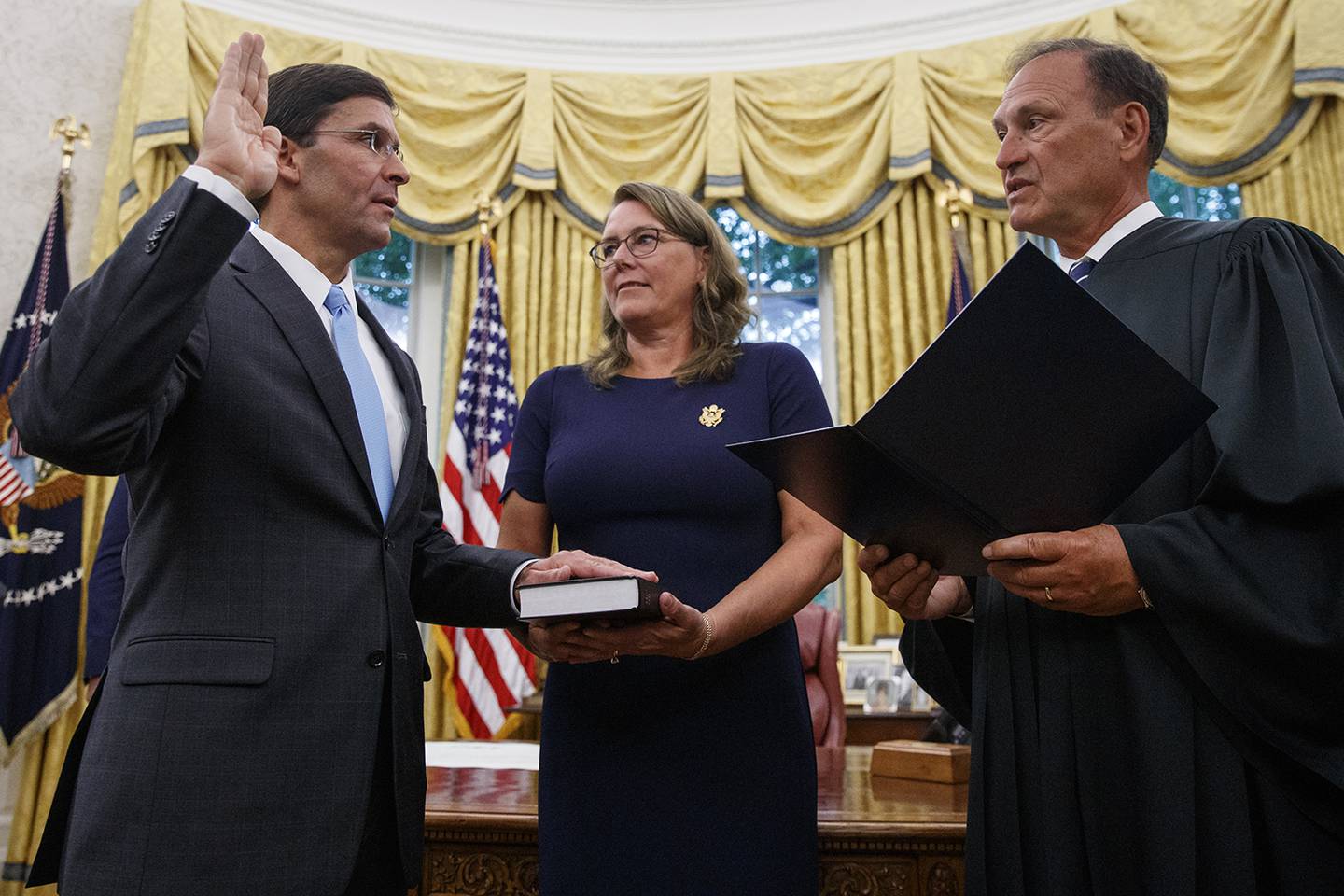 Mark Esper, left, is sworn in as the Secretary of Defense by Supreme Court Justice Samuel Alito, right, as his wife Leah Esper holds the Bible, during a ceremony with President Donald Trump in the Oval Office at the White House in Washington, Tuesday, July 23, 2019.