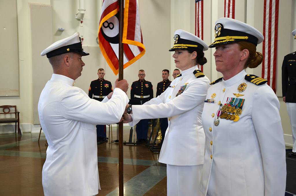 Cmdr. Lena Kaman receives the Helicopter Training Squadron 8 command colors from Chief Petty Officer Robert Hand