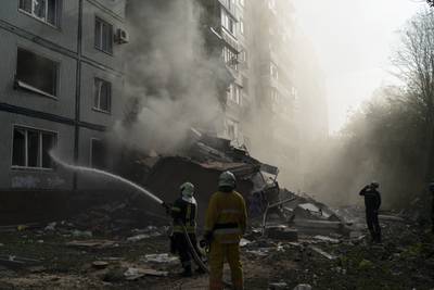 Firefighters work at the scene where a residential building was heavily damaged after a Russian attack in Zaporizhzhia, Ukraine, Sunday, Oct. 9, 2022.