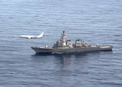 A P-8A Poseidon aircraft flies alongside the Arleigh Burke-class guided-missile destroyer USS Porter (DDG 78) during a photo exercise, March 29, 2020, in the Atlantic Ocean.