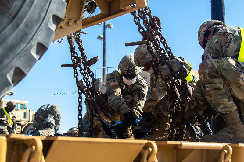 Motor Transport Operators with 1st Cavalry Division Sustainment Brigade unfasten a vehicle from a rail-cart during railhead operations, Fort Hood, Texas, June 8, 2020.