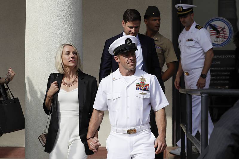 Navy Special Operations Chief Edward Gallagher, center, walks with his wife, Andrea Gallagher, as they leave a military court on Naval Base San Diego, Tuesday, July 2, 2019, in San Diego.