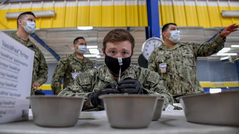 Hospital Corps Officer 2nd Class Shane Miller prepares COVID-19 vaccines at the San Diego Naval Base fitness facility on January 8, 2020, as part of Operation Warp Speed.