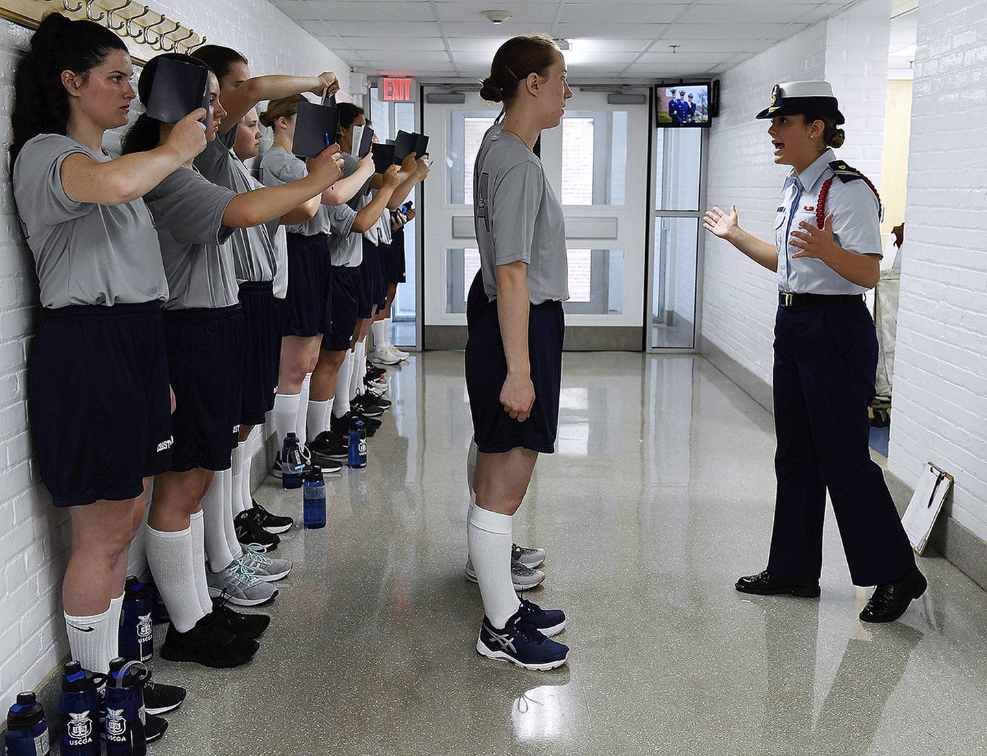 In this July 1, 2019, file photo, female swabs learn the positions of attention and parade rest while their male classmates get haircuts during the first day of a seven-week orientation for the Class of 2023 at the U.S. Coast Guard Academy in New London, Conn.