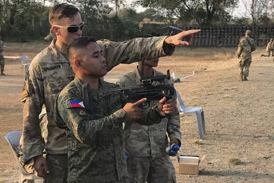 Cpl. Cale Splivalo, a soldier with 5th Battalion, 20th Infantry Regiment, teaches an Armed Forces of the Philippines soldier how to operate the M320 Grenade Launcher Module March 11, 2019, at Nueva Ecija Province, Philippines.