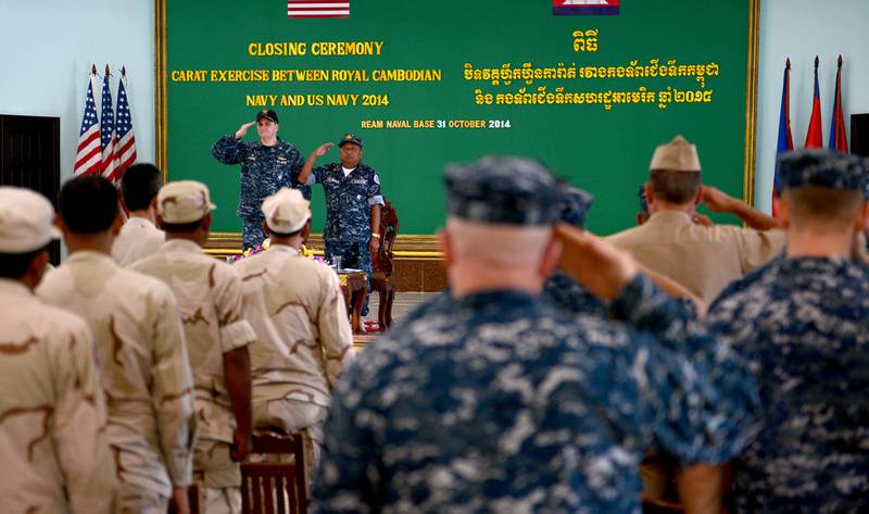 Capt. Fred Kacher, commander of Destroyer Squadron (DESRON) 7, and Rear Adm. Ros Veasna, deputy commander of Ream Naval Base, salute during the closing ceremony of Cooperation Afloat Readiness and Training (CARAT) Cambodia 2014.