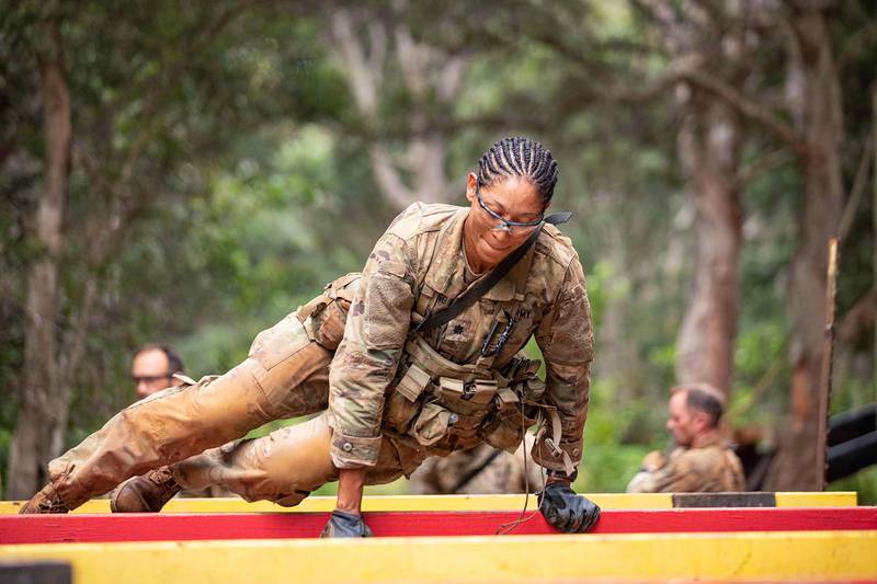 Lt. Col. Paula Young, Brigade Surgeon, 25th Infantry Division Sustainment Brigade, hurdles over an obstacle during the Green Mile, a physical endurance course that concludes the final week of Jungle Operations Training Course at East Range, Hawaii, on Oct. 1, 2020.