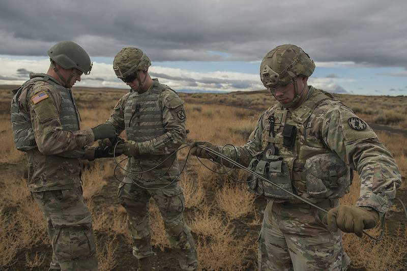 Army Spcs. Timothy Martin, left, and Shane Flores, middle, and Cpl. Dario Martinez prepare for a detonation during training in Boise, Idaho, Nov. 18, 2020.