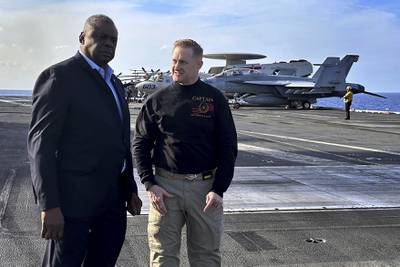 Defense Secretary Lloyd Austin, left, talks with the commanding officer of the USS Gerald R. Ford, Navy Capt. Rick Burgess, during an unannounced visit to the ship on Wednesday, Dec. 20, 2023.
