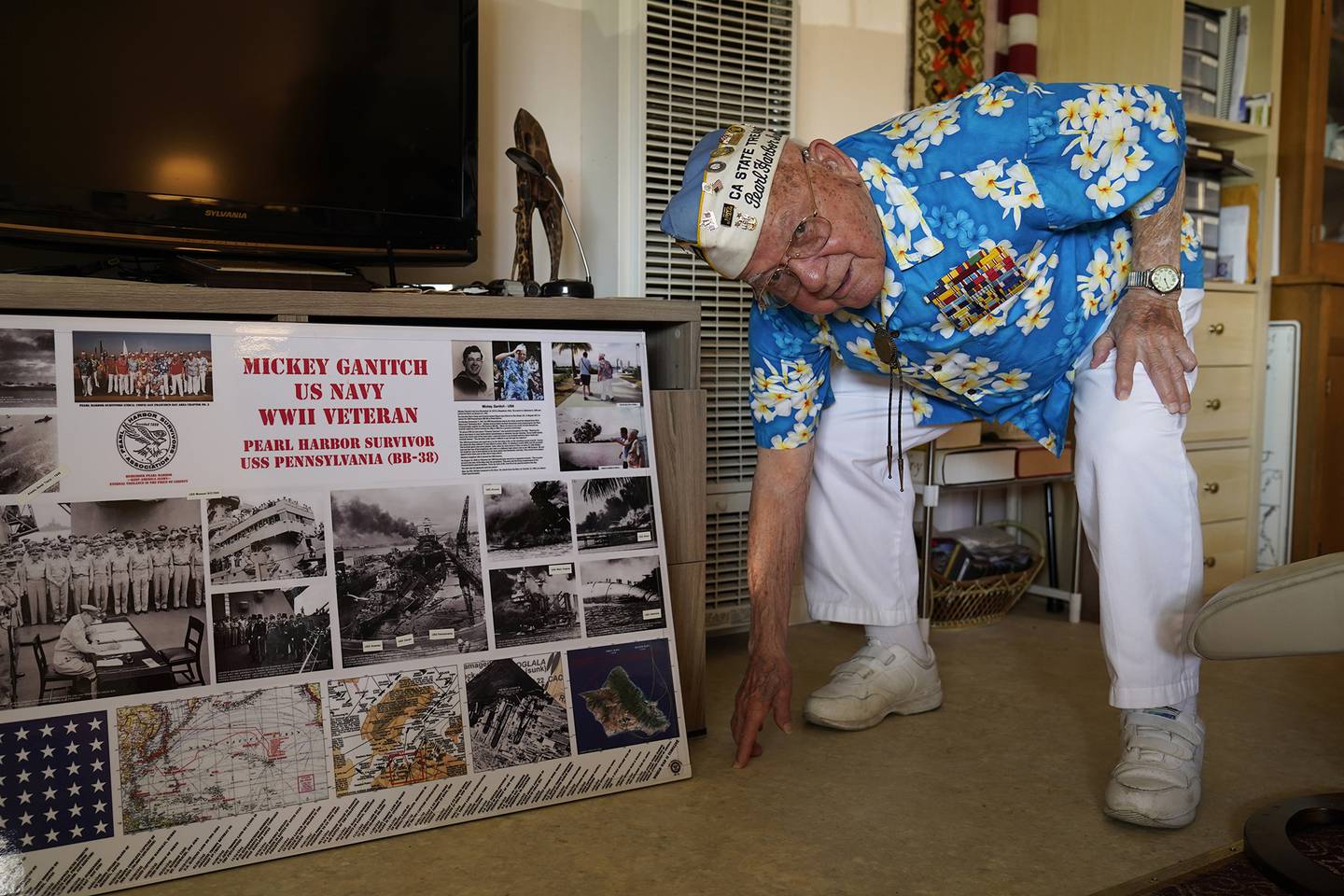 Mickey Ganitch, a 101-year-old survivor of the attack on Pearl Harbor, drops down to display his football stance in the living room of his home in San Leandro, Calif., Nov. 20, 2020.