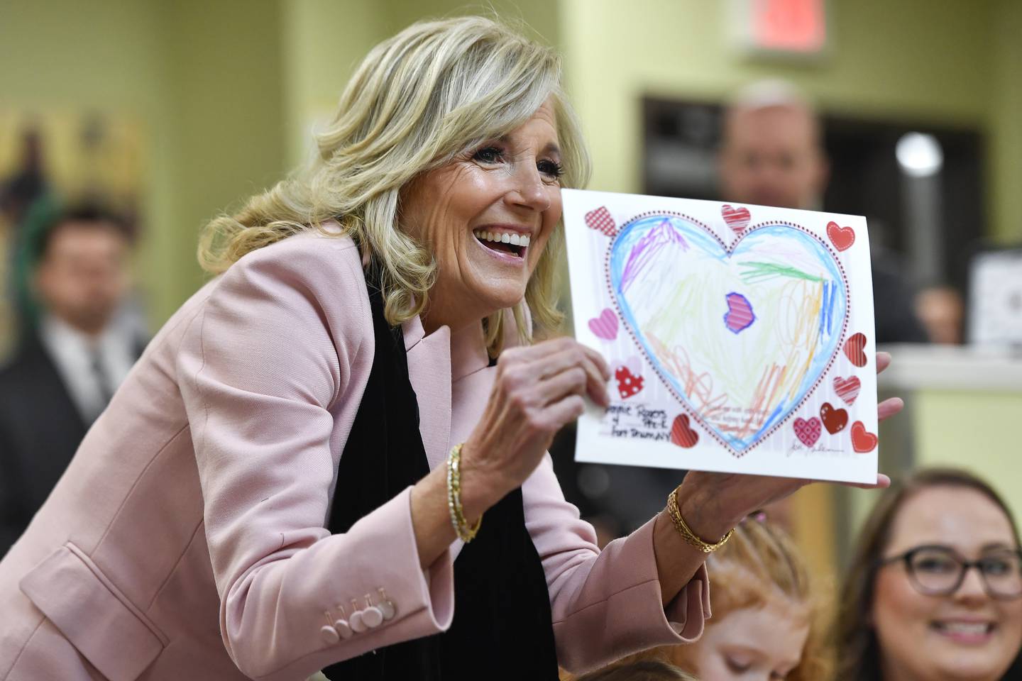 First lady Jill Biden shows a "Hearts and Crafts," Valentine's Day card made by children at the South Riva Ridge Child Development Center in Fort Drum, N.Y., Monday, Jan. 30, 2023.