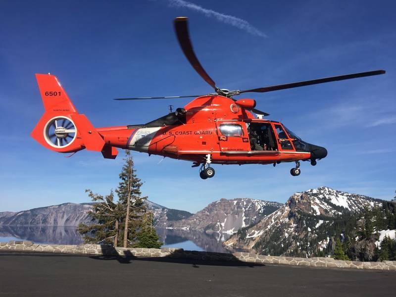 An MH-65 Dolphin helicopter lands at a parking area to transfer an injured man to AirLink Critical Care Transport on June 10, 2019, at Crater Lake National Park in Oregon.