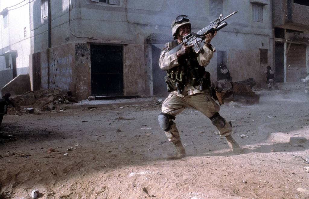 A military man in combat in a scene from the 2001 film "Black Hawk Down."