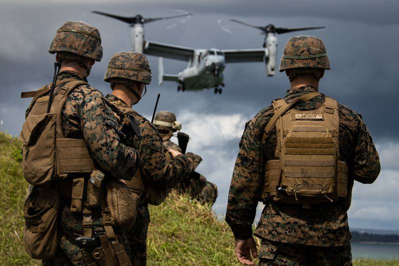U.S. Marines observe an MV-22B Osprey preparing to land during a simulated embassy reinforcement at Kin, Okinawa, Japan, Sept. 12, 2020.