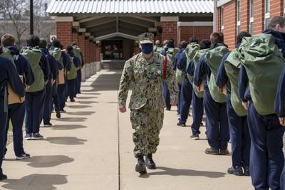 Chief Interior Communications Electrician Joseph Christensen instructs recruits as they arrive at Recruit Training Command at Great Lakes, Ill., on May 4, 2020, following a 14-day restriction-of-movement period at an off-site facility.